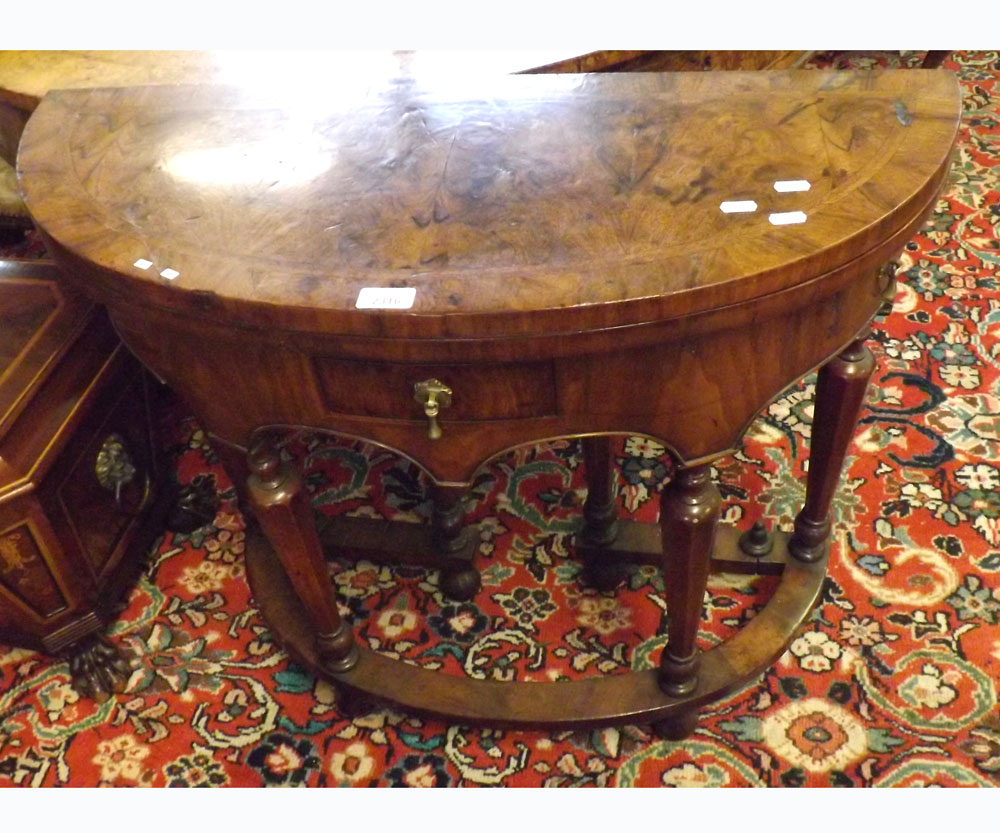 A Queen Anne period Walnut Games Table of oval form with folding top and double gate leg support,