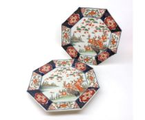 A pair of Imari octagonal Plates, the centres decorated with Chinese river scenes with perched