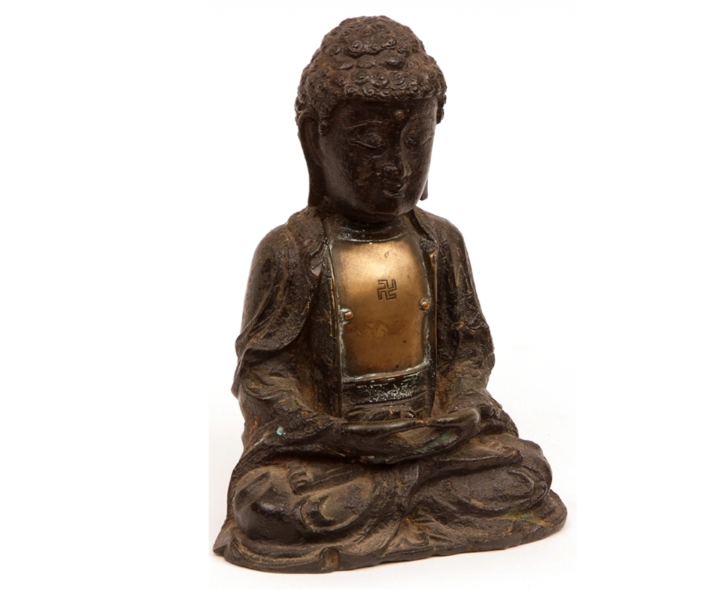 A Tibetan painted Bronze figure of a seated Buddha, his chest applied with a gilt metal plaque with