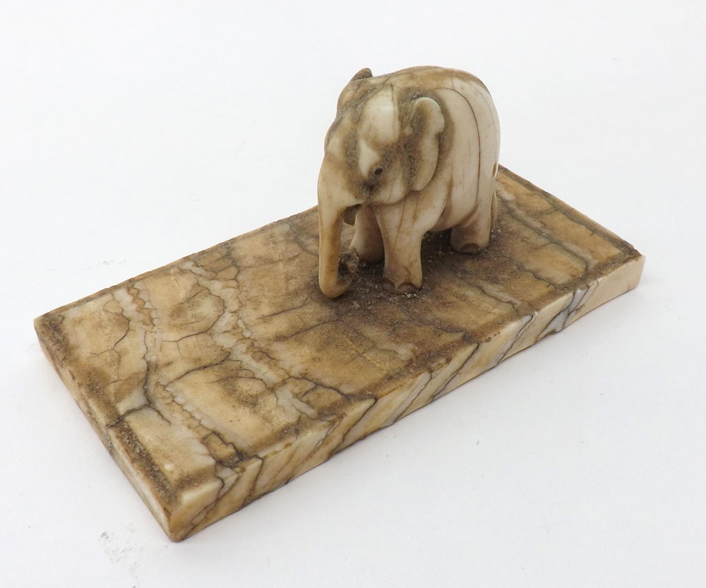 A carved Ivory Model of an Elephant standing on a rectangular base, 2? high