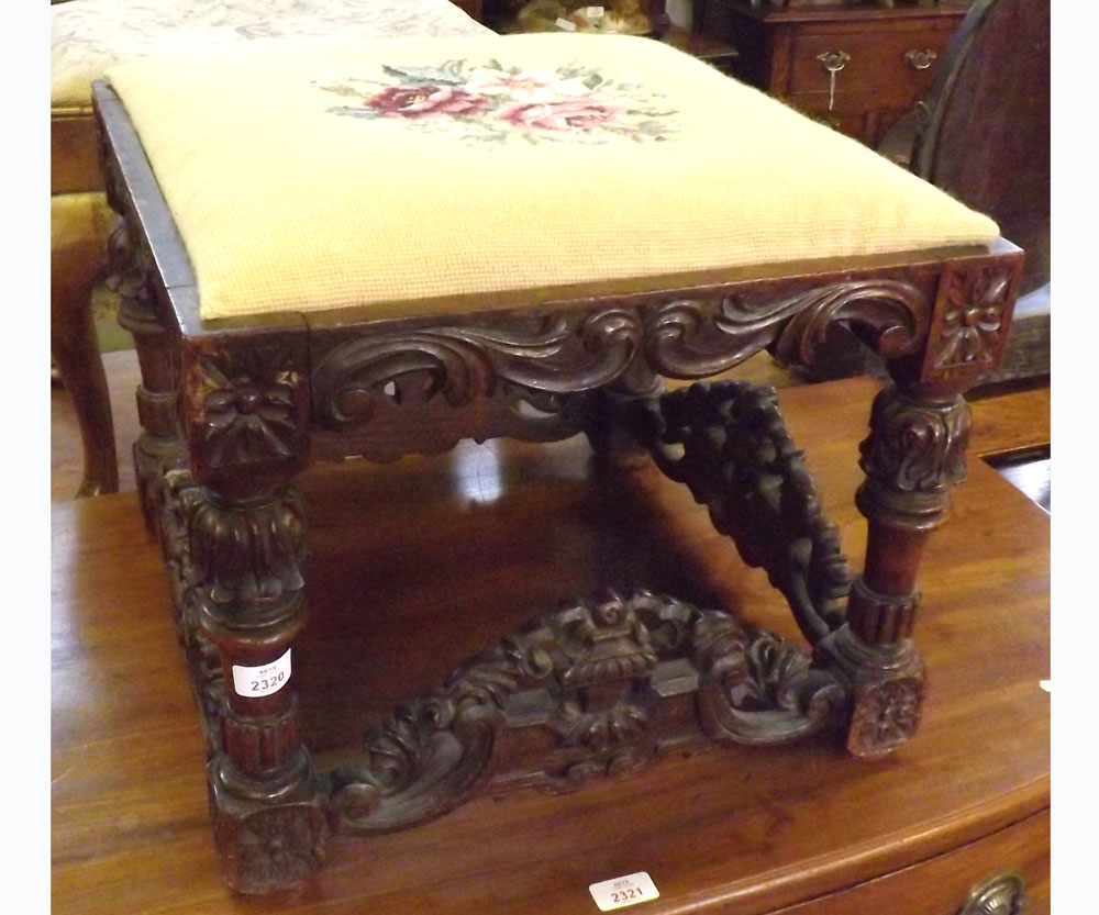 An Oak Stool of square form, the frieze carved with scrolls and rosettes, raised on four foliate