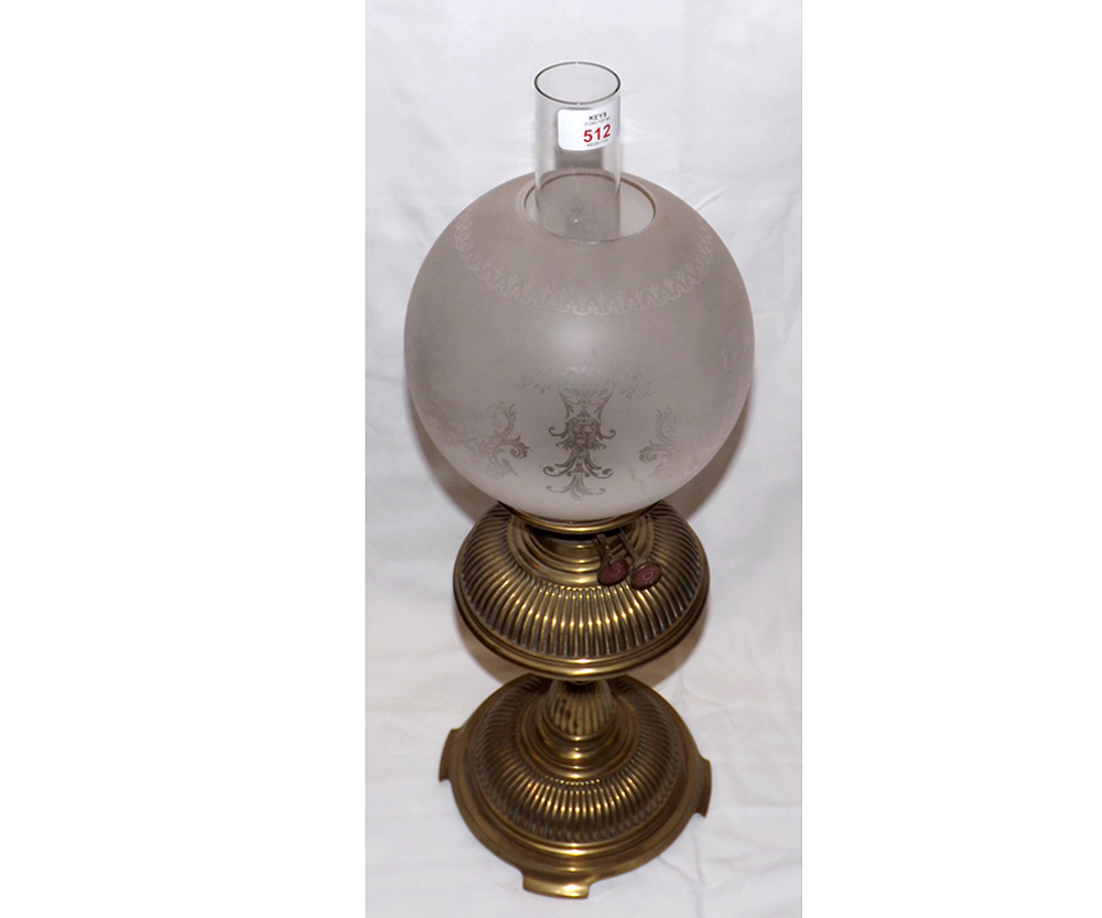 A Victorian Oil Lamp with clear glass chimney, frosted glass cherub decorated shade to a fluted