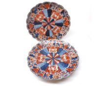 A near pair of Imari Dishes of circular form with hipped rims, the centres with raised spreading
