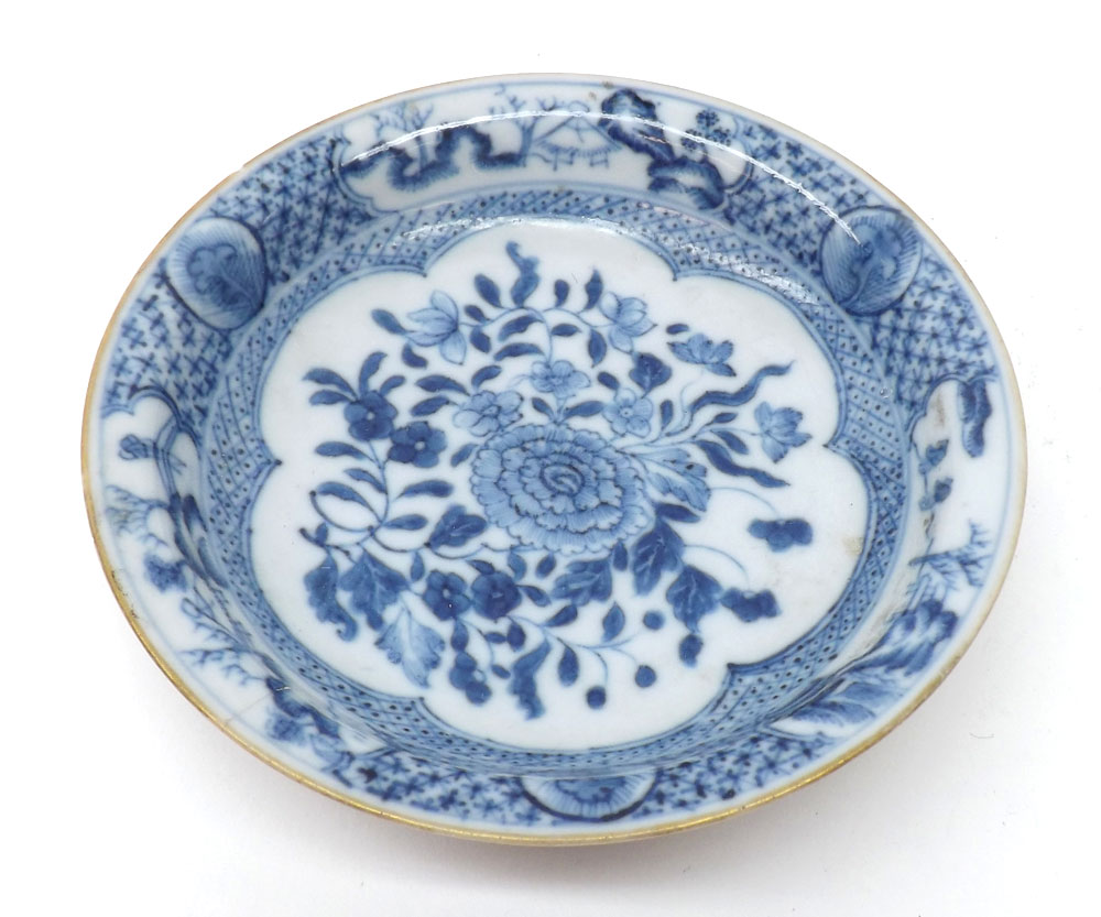 A Chinese circular Saucer, painted in under glazed blue with a central floral spray within a
