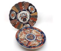 Two Imari circular Plates, one with a scalloped rim, both painted in traditional colours with