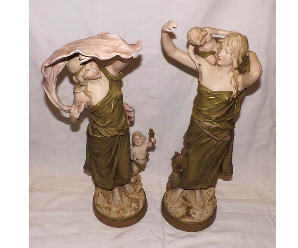 A pair of large Royal Dux Bohemia models of young female figures with accompanying cherubs, the
