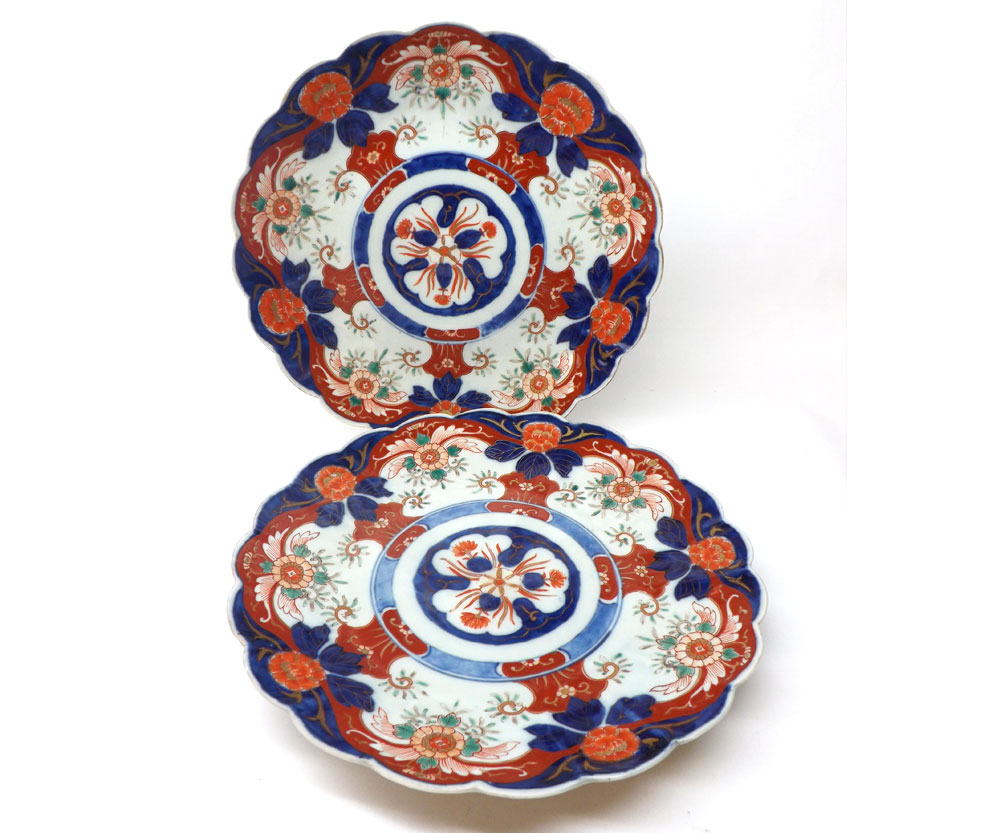 A pair of Japanese Imari Plates with hipped rims, the centres decorated with rosette designs within