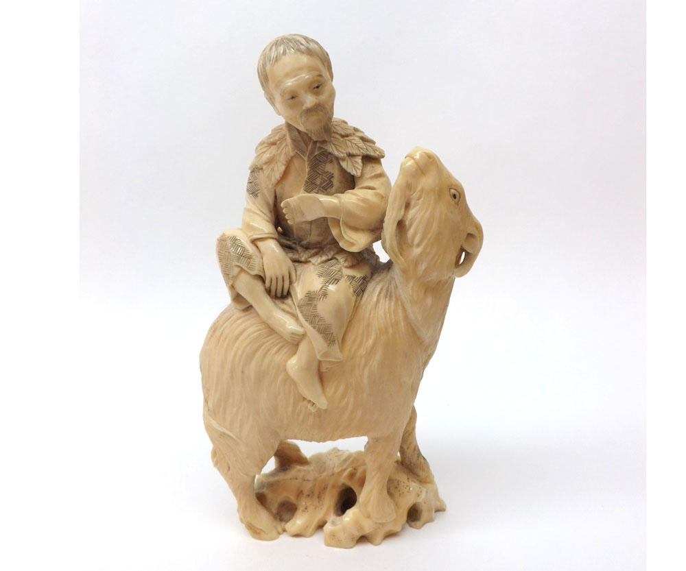 A Japanese Meiji Period carved Model of a male figure seated on a goat, well detailed, 6? high