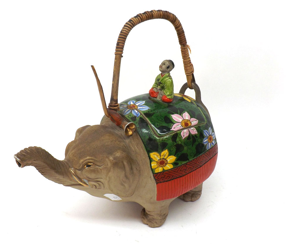 An unusual Oriental Teapot in the form of an elephant with lift-off cover, with a figure finial and