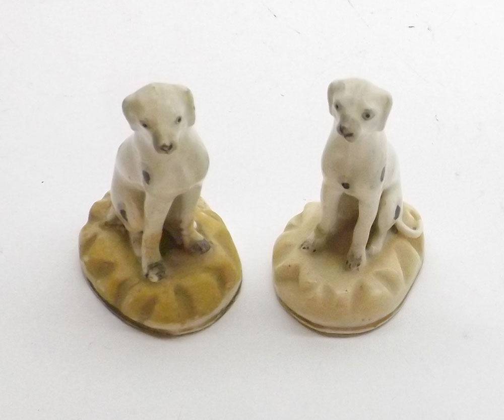 A pair of Rockingham Models of seated Dalmatians with naturalistic faces and bodies, raised on lemon