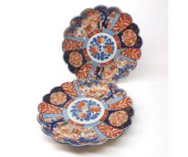 A pair of Imari circular Dishes with hipped rims, the borders decorated with compartmentalised