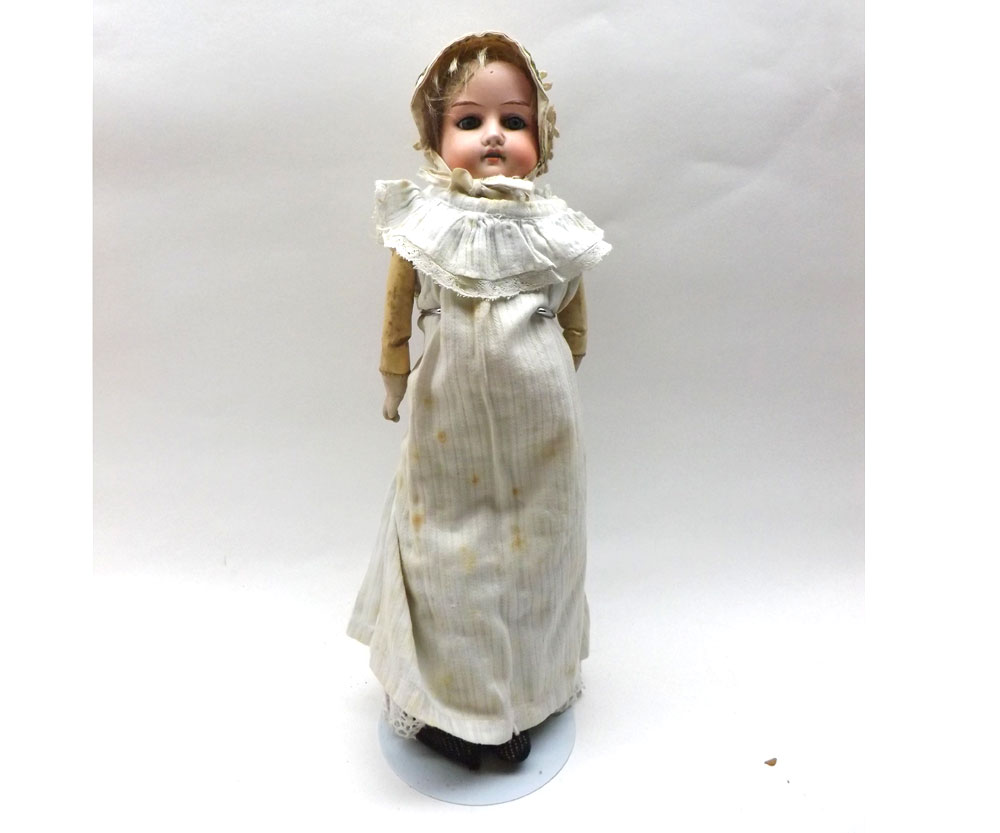 An early 20th Century Bisque Head and Shoulder Plate Doll, with fixed blue glass eyes, painted