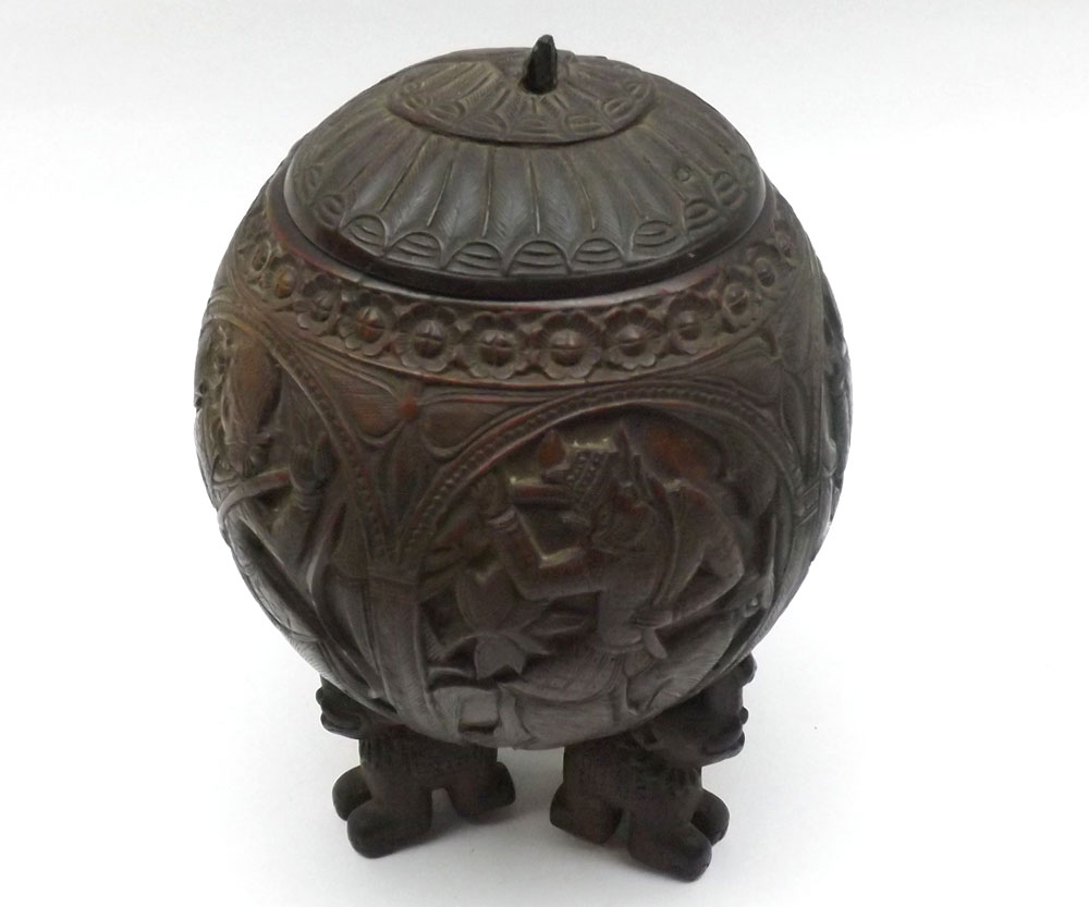 A Carved Siamese Coconut Container with cover, the body decorated all over with various figures,