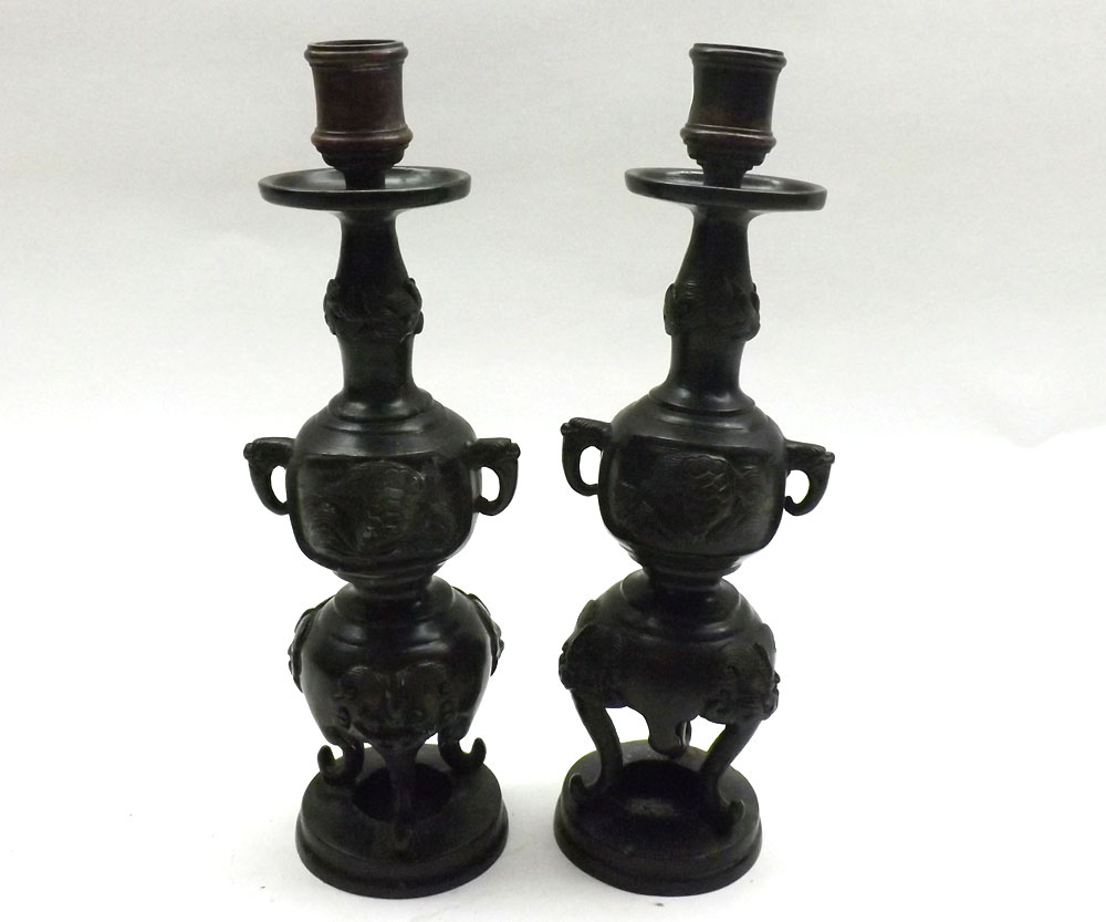 A pair of Oriental Bronze finish Candlesticks, the bulbous stems decorated with various dragons,