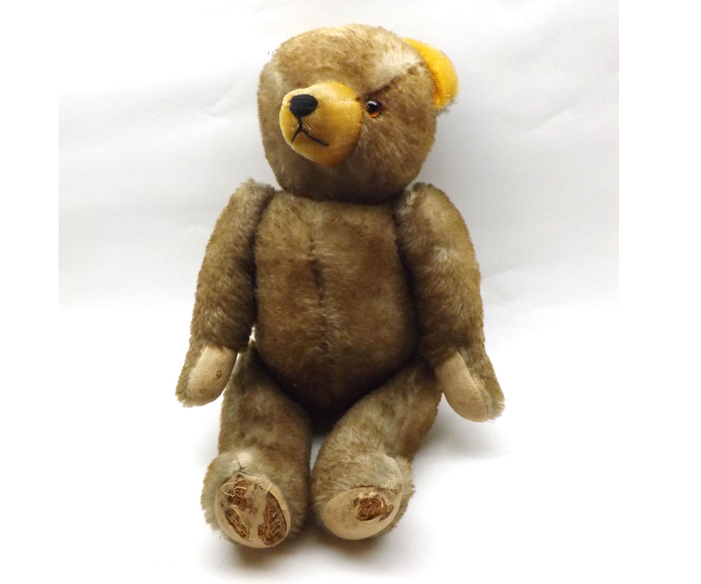 An early 20th Century Straw-Filled Shaded Brown Mohair-Covered Teddy Bear, amber glass eyes with