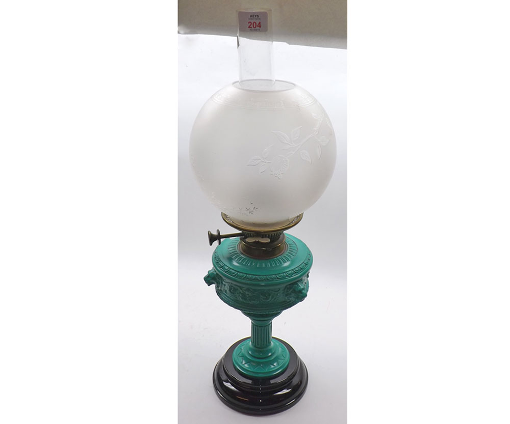 A 19th Century Oil Lamp with clear glass chimney, round fronted glass shade to a green painted cast