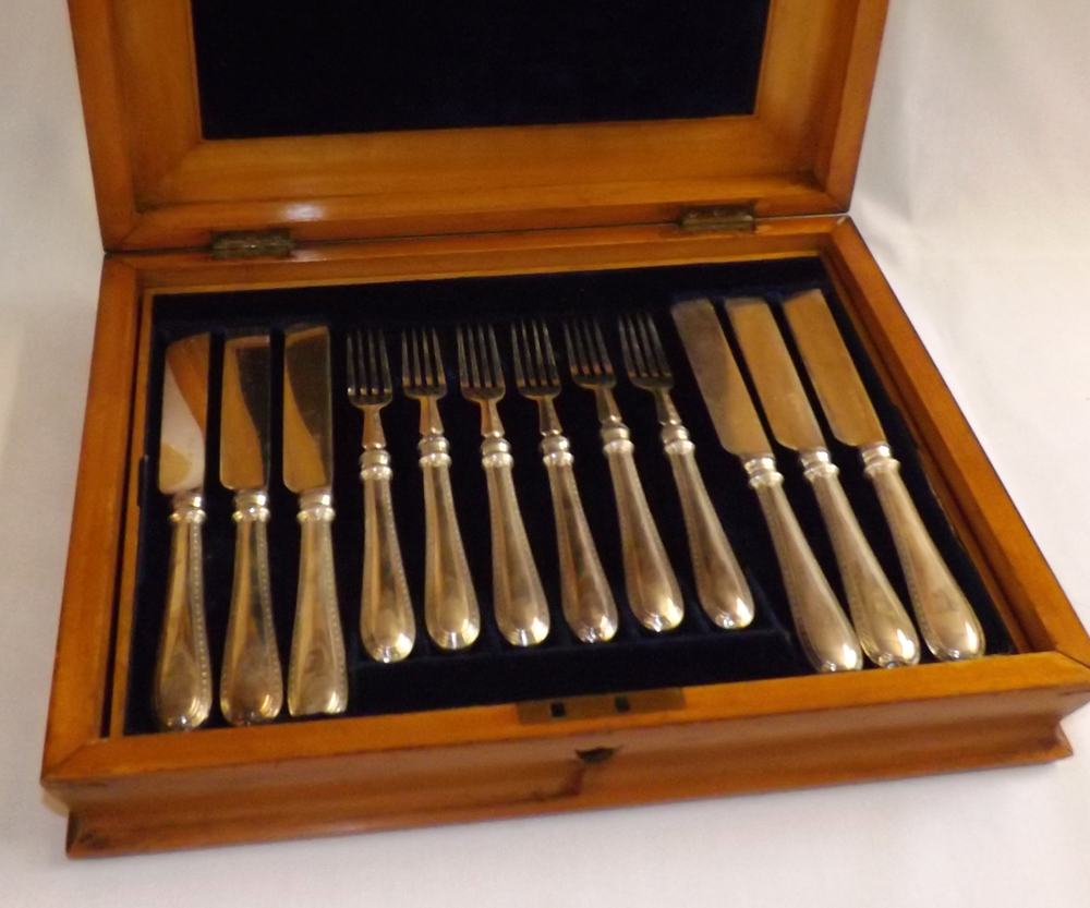 A cased set of six Elkington & Co Silver Plated Dessert Knives and Forks, in a blue plush-lined