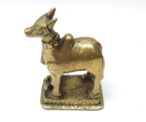 An Oriental Brass Model of a cow decorated in the naïve manner, 4 ¾” high