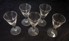 A set of five 19th Century Clear Small Wine Glasses on plain stems and spreading circular feet, all