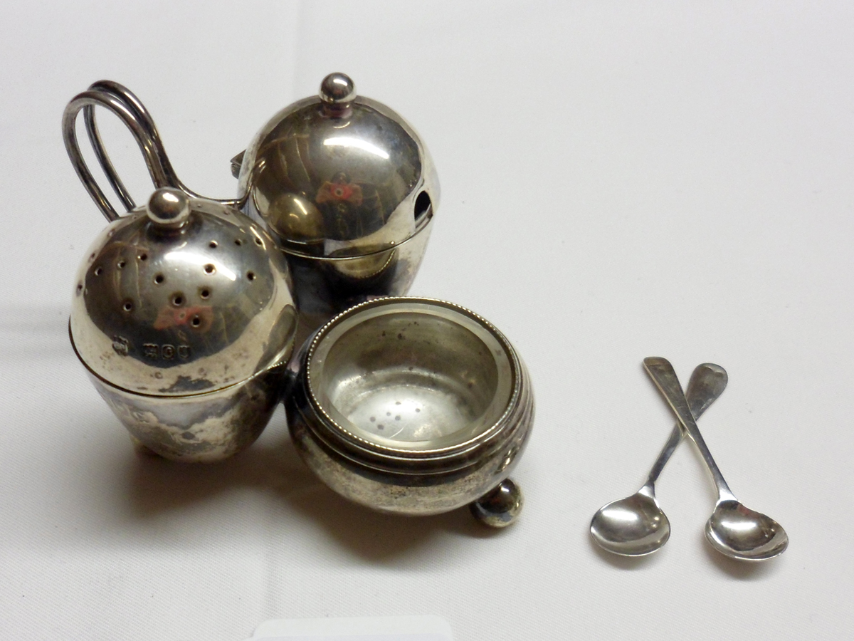 A late Victorian Cruet, with integral stand, comprising glass-lined Salt, egg-shaped Pepper Pot and