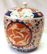 A Japanese Imari Cylindrical Covered Jar, typically decorated in traditional colours, (cover with