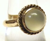 A Circular Moonstone Dress Ring with rope twist surround, yellow metal, marks unclear