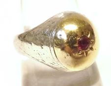 An unmarked mix metals Signet type Ring, the bulbous centre set with a small Ruby