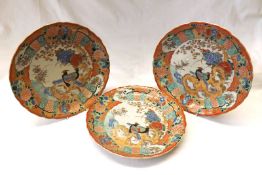 A set of three Kutani Plates, the centres decorated with exotic birds and foliage, within a