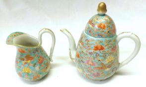 An Oriental small bullet-shaped Teapot and matching Cream Jug, each gilded and decorated in