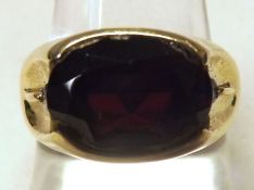 A Gents Oval Cut Garnet and two small White Stone Ring, stamped “14K”