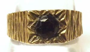 A Gents Signet Ring set with a single Garnet, bark engraved shoulders, hallmarked 9ct Gold