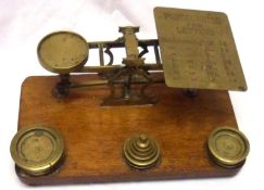 A set of Vintage Brass Postal Scales and set of graduated weights, on oak plinth base, 9” wide
