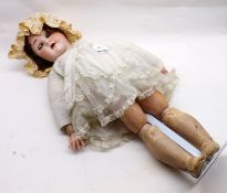 An early 20th Century German Bisque Socket Head Doll, with weighted blue sleep glass eyes, painted