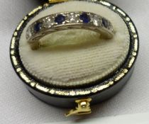 A hallmarked 18ct White Gold Half Hoop Ring, channel set with four Mid-Blue Sapphires (worn) and
