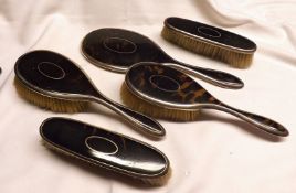 A George V Four Piece Silver and Tortoiseshell Backed Dressing Table Set, comprising Hand Mirror and