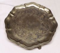 A George IV Salver with moulded rim, engraved foliate centre, raised on three acanthus leaf legs