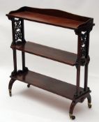 A Victorian Three Tier Rosewood Shelf, with fretwork side detail and raised on brass castors, 33”