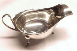 A Queen Elizabeth II Sauceboat, of typical form with looped handle, raised on three swept feet,