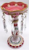 A Victorian Cranberry and White Overlaid Glass Lustre Vase with extensive cut detail and painted