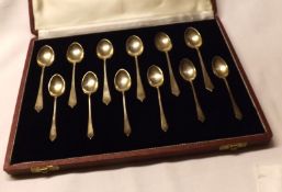 An unusual Cased Set of Six 20th Century Teaspoons and accompanying Six Coffee Spoons, showing the