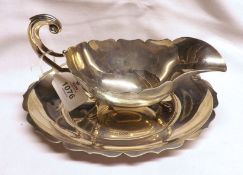 A George VI Oval Sauceboat, raised on three hoof feet, with oval stand with card cut edge, weight
