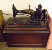 An early 20th Century Family Sewing Machine, black cast iron with gilt highlights, housed within