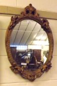 A 20th Century Oval Wall Mirror, in plasterwork frame with cherub mount, 17” wide