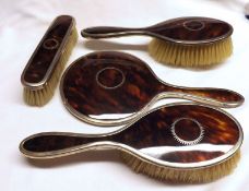 A George V Four Piece Silver and Tortoiseshell Dressing Table Set comprising: Hand Mirror and