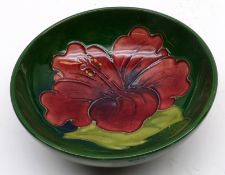 A Moorcroft Small Pedestal Dish, decorated in a Hibiscus pattern, red flower on a green