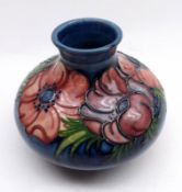 A Moorcroft Anemone pattern Squat Wide-Necked Vase, decorated with coloured flowers on a blue