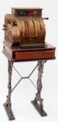 An early 20th Century Brass National Cash Register, No 1306974 417X, secured to a mahogany topped