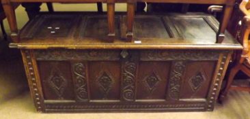 An early 18th Century Oak Coffer with plain four panelled top, the four panelled front incised