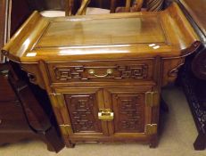 An Oriental Hardwood Desk with plain moulded centre, central moulded frieze drawer over two