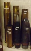 Four assorted Brass Shell Cases, 14 ½”, 24”, 26 ½” and 28 ½”; together with two Dummy Shell Heads,